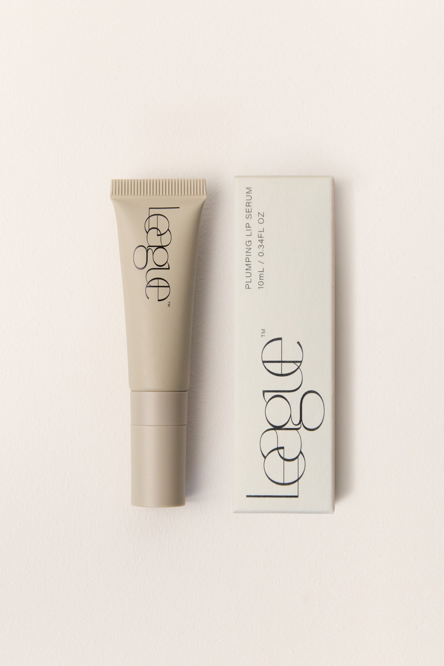 Lip serum tube and packaging with 'League' branding on a light beige background