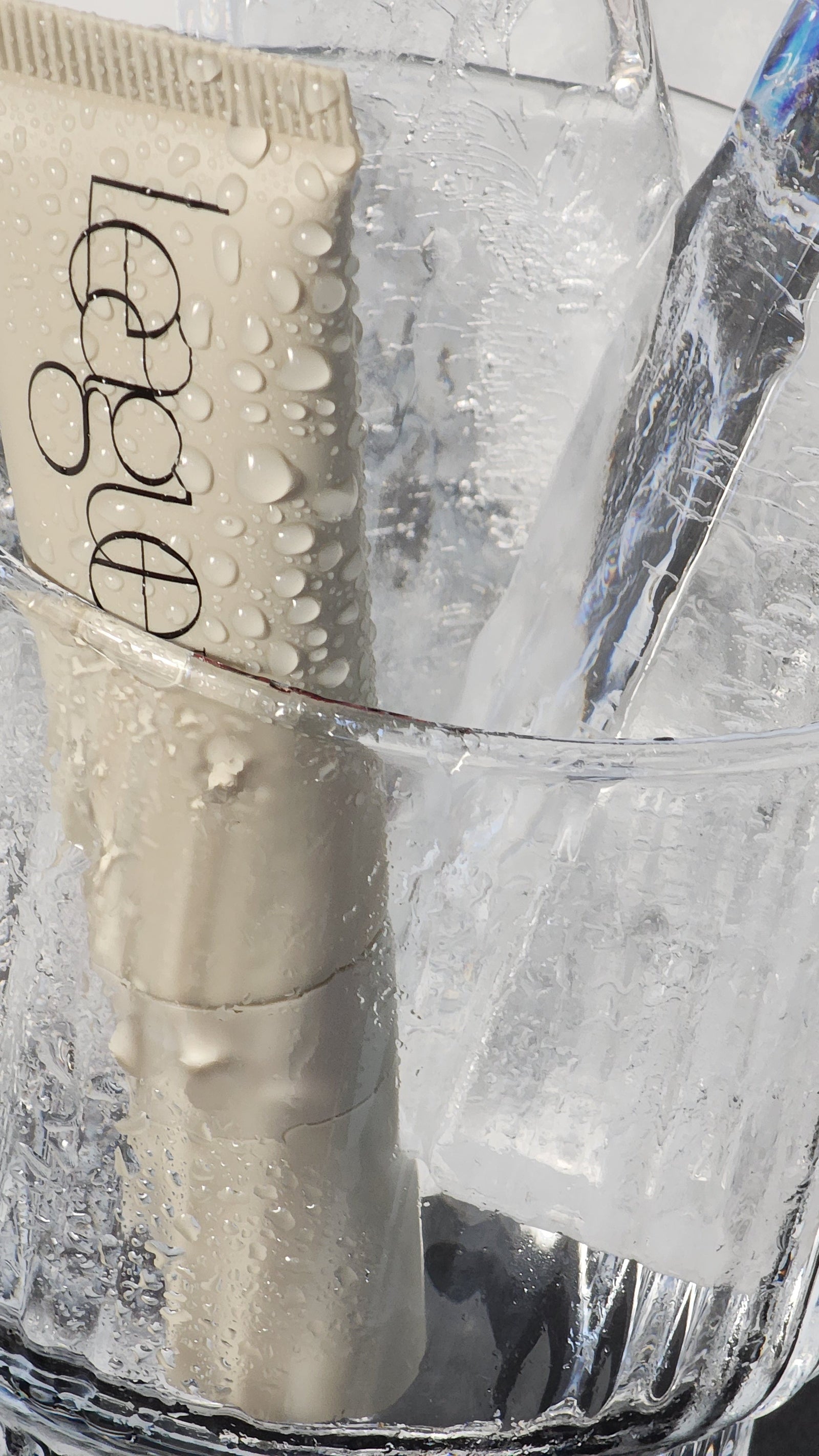 tube of league beauty plumping lip serum in glass of ice