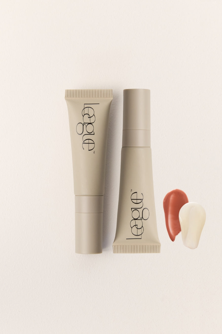 Two tubes of League lip serum on a light beige background