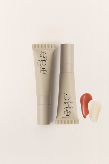 Two tubes of League lip serum on a light beige background