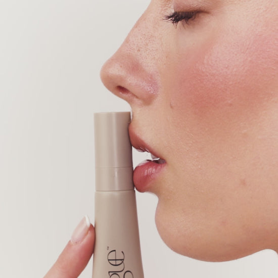 product application video of a blonde model applying a beige tube of lip gloss