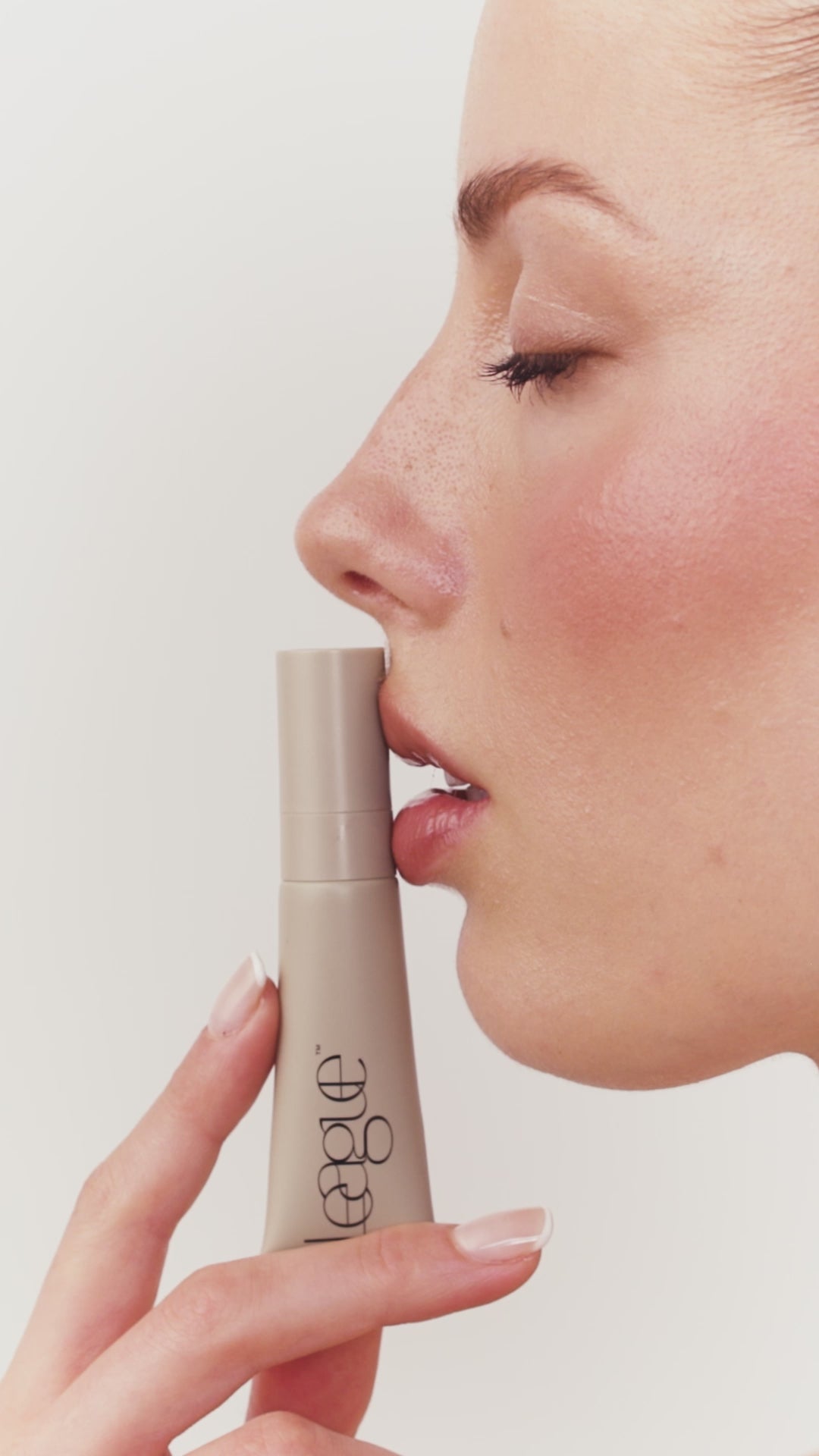 product application video of a blonde model applying a beige tube of lip gloss