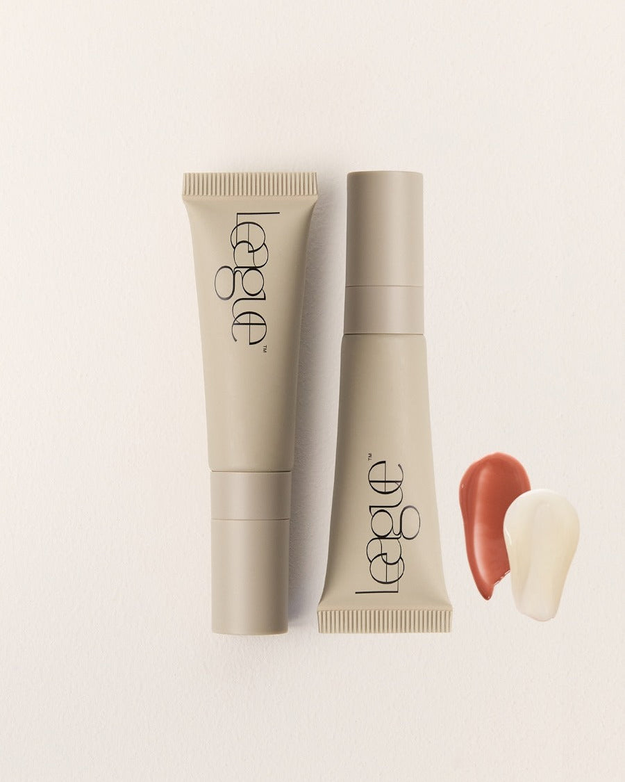 Two beige cosmetic tubes and clear and rose product swatches with 'League' branding on a light background